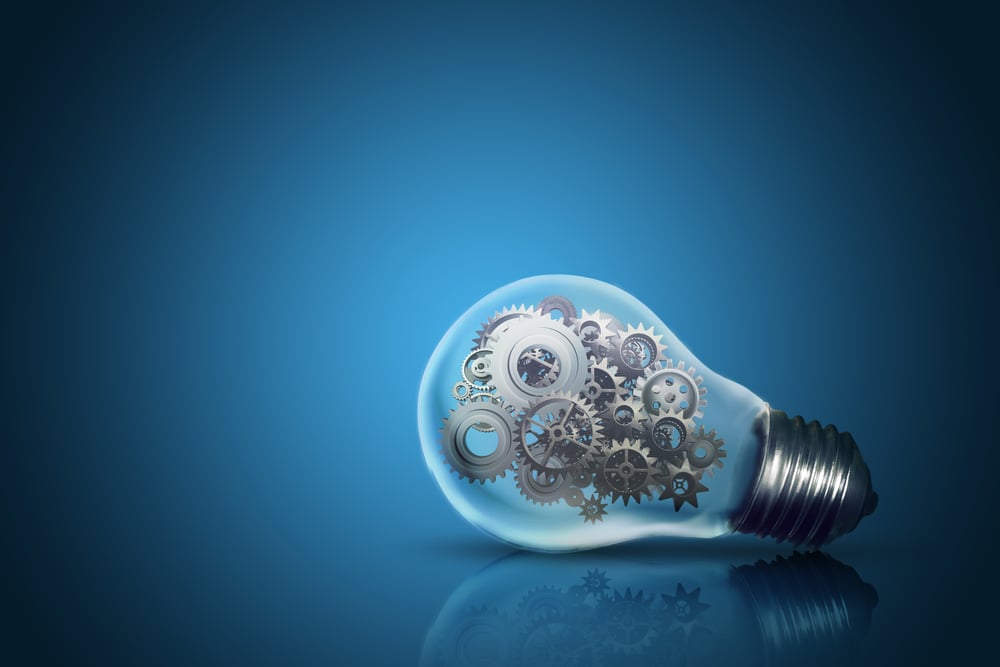 Light bulb filled with gears blue background